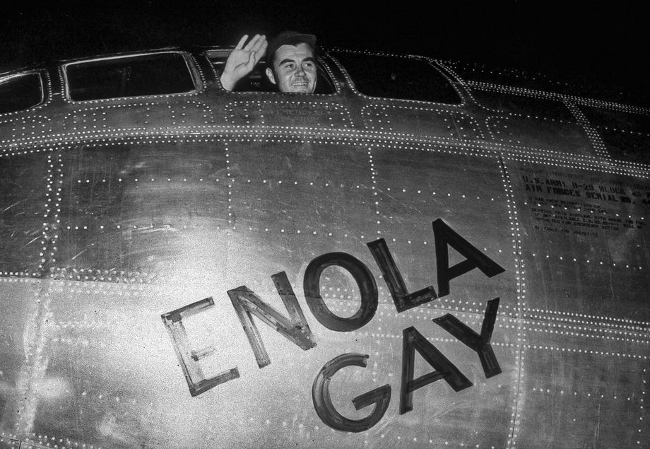 Командир экипажа полковник Пол Тиббетс машет рукой из кабины своего бомбардировщика перед вылетом на Хиросиму. Накануне Тиббетс назвал свой самолет B-29 Superfortress «Энола Гэй» в честь матери. 6 августа 1945 года.