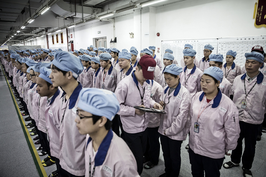 Супервизор проверяет карты сотрудников завода Pegatron Corp. в Шанхае во время штатной переклички. Здесь производятся самые популярные смартфоны в мире – iPhone.