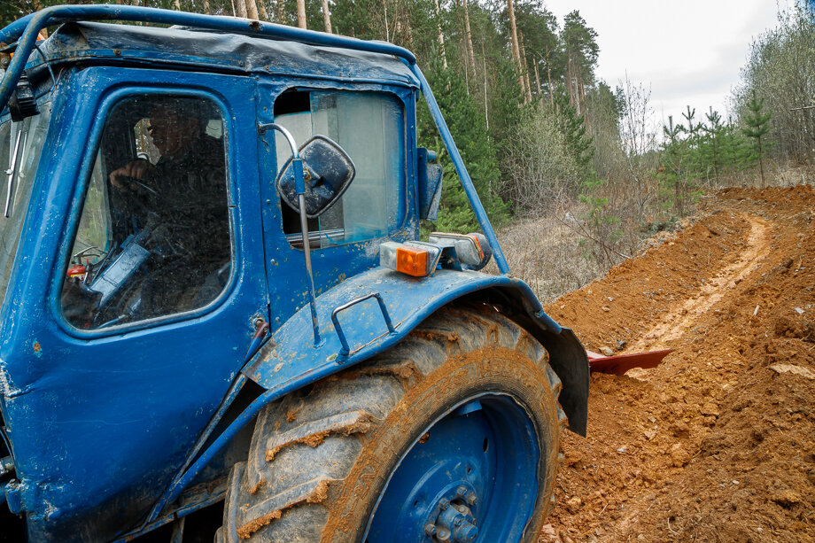 Тракторист Сергей Рыбин прокладывает минерализованную полосу вдоль лесного массива рядом с посёлком Садовый.