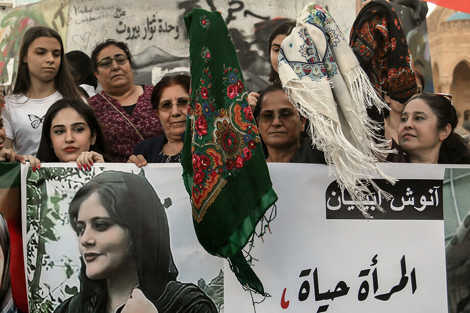 Женщины во время протеста машут платками, держа в руках фотографии умершей Махсы Амини, 22-летней иранки, которая была арестована иранской полицией за то, что её одежда не соответствовала стандартам страны.