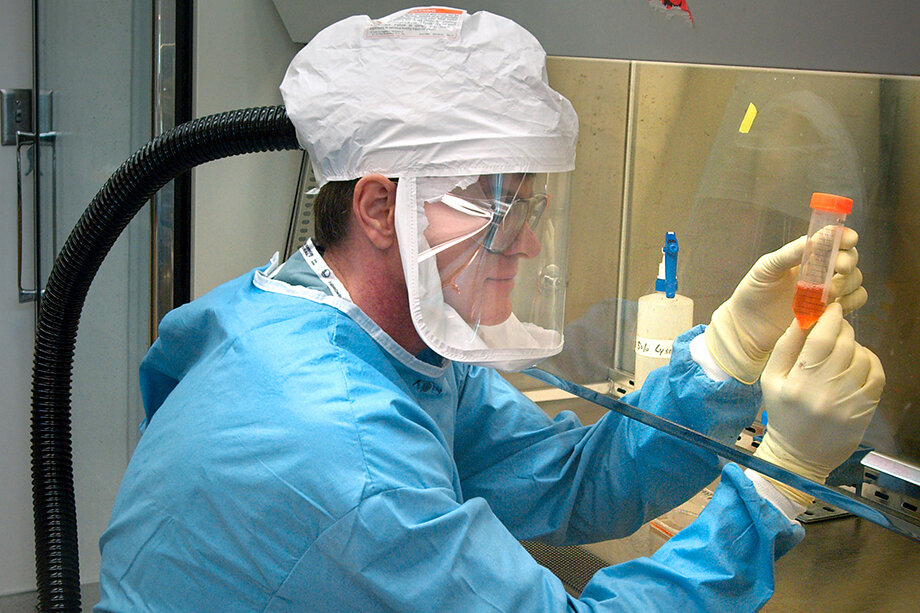 Научный сотрудник Центров по контролю и профилактике заболеваний США, работающий с вирусом гриппа в лаборатории уровня BSL-3.