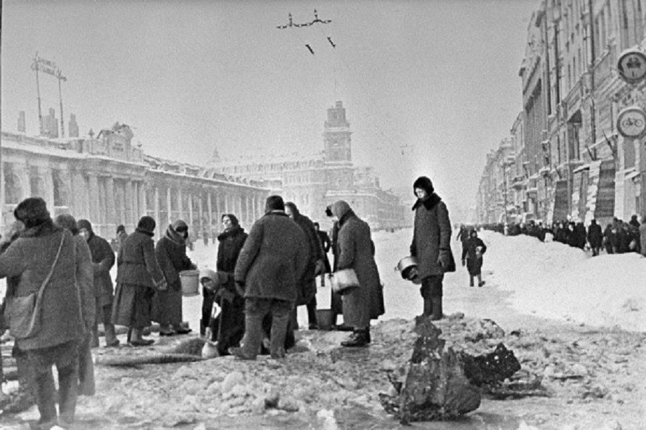 Декабрь 1941 года. Жители блокадного Ленинграда набирают воду, появившуюся после артобстрела в пробоинах в асфальте на Невском проспекте.